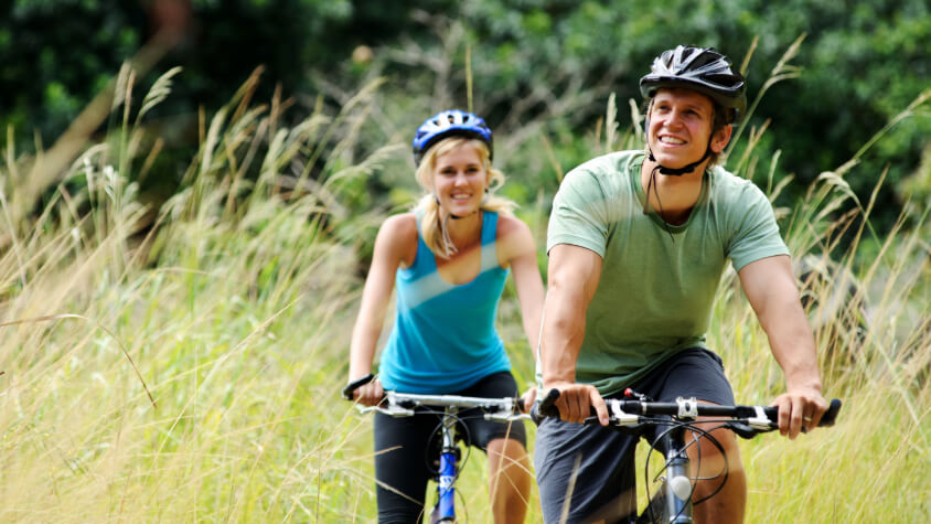 A man and a woman riding bicycles