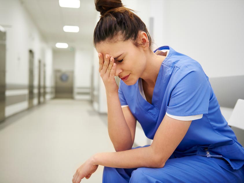 A nurse sitting in a hospital corridor